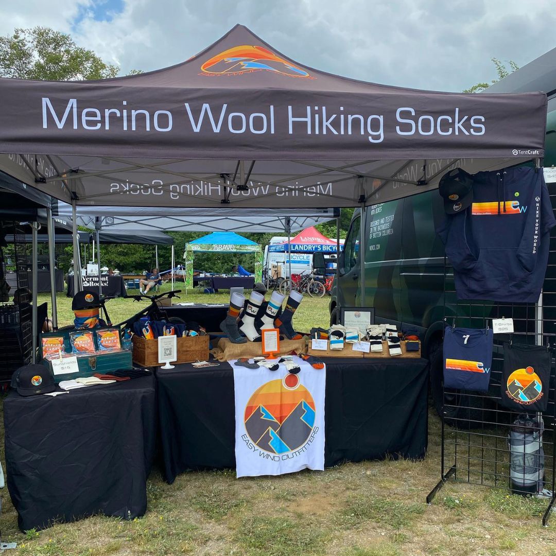 Merino Wool Hiking Socks booth with products and branding at an outdoor event.